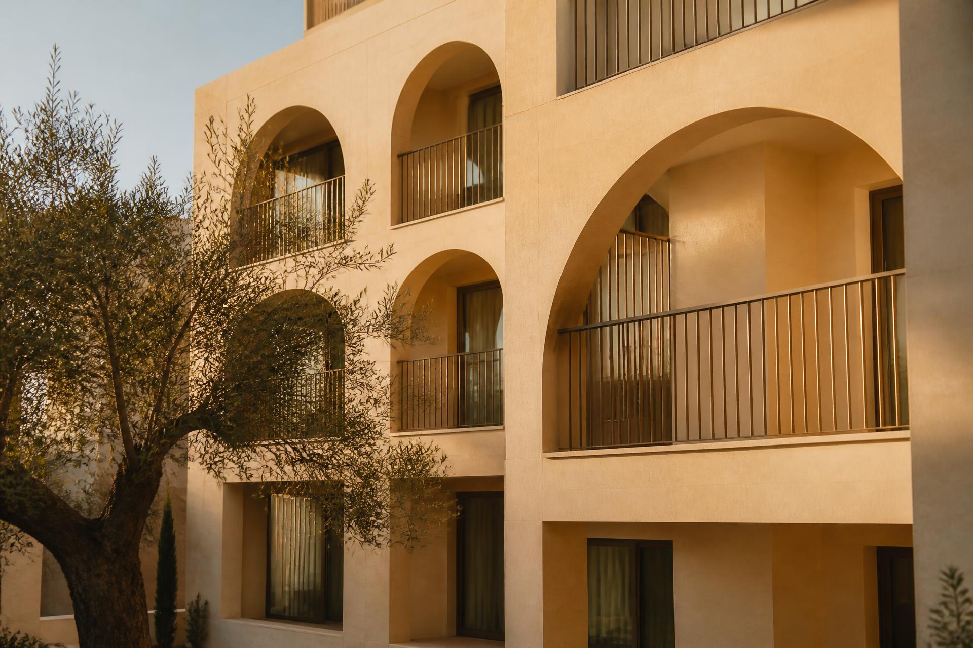 A Domus development in Malta, pale limestone facade with deep arched balconies